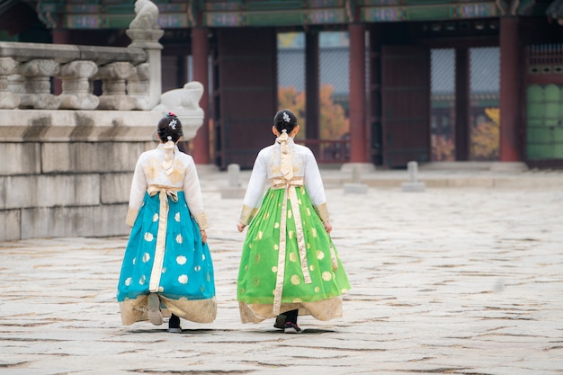 사진 한국 여성 두 명은 한국의 전통 복을 입고 서울의 경복궁을 방문한다. 관광, 여름 휴가 또는 관광 서울 랜드 마크 컨셉