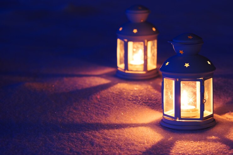 Photo two lantern with burning candle on snow in the evening. tinted photo