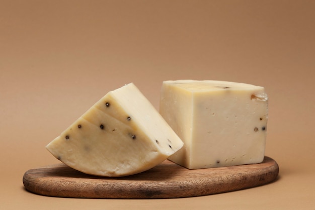 Photo two large pieces of flavored italian caciotta cheese with black peppercorns