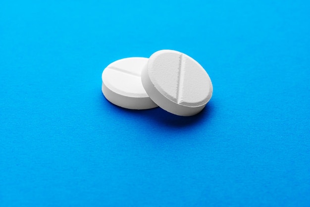 Two large white effervescent tablets on a bright blue background