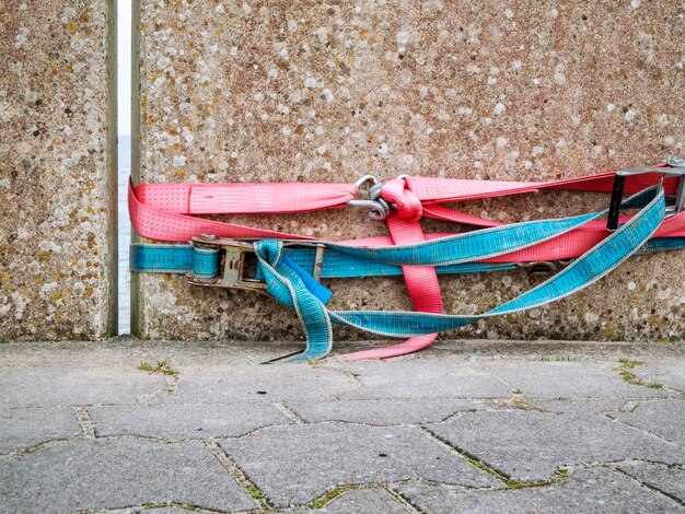 Photo two lashing straps in red and blue on the concrete quay wall in harlesiel harbor