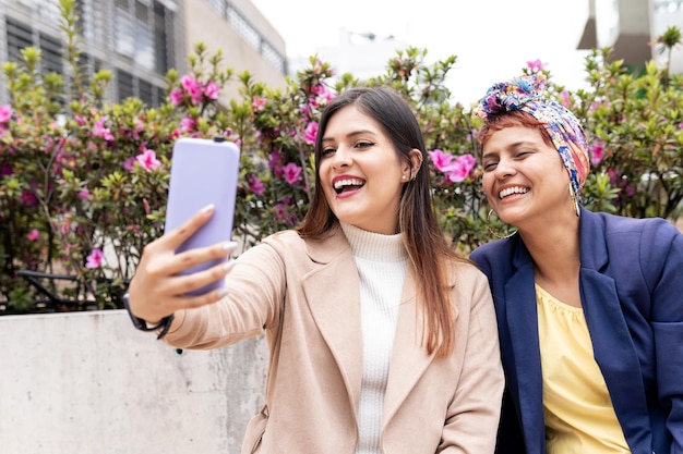 Two Latin adult woman smile and take selfie