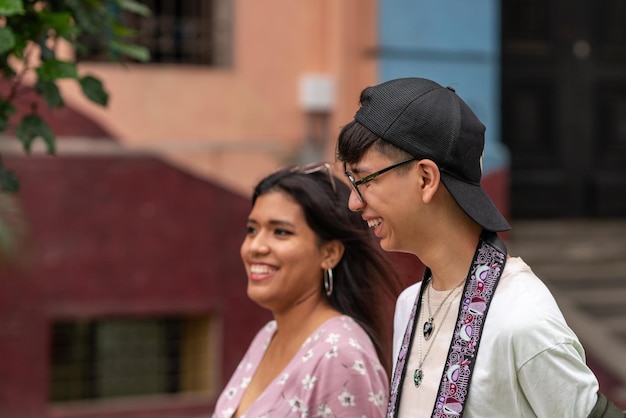 Two latin friends smiling while walking in the street