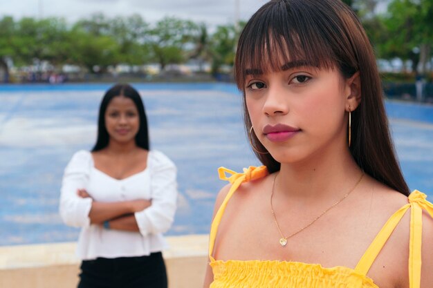 Photo two latin women, beautiful modern ladies standing on the city street