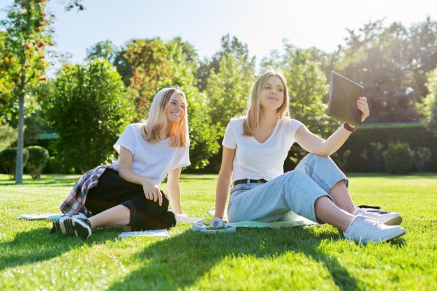 Due studenti di sesso femminile che ridono che usano la tavoletta digitale per la comunicazione video