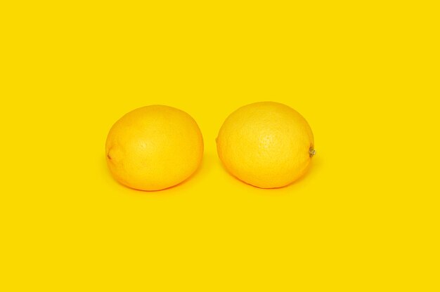 two lemons on a yellow background