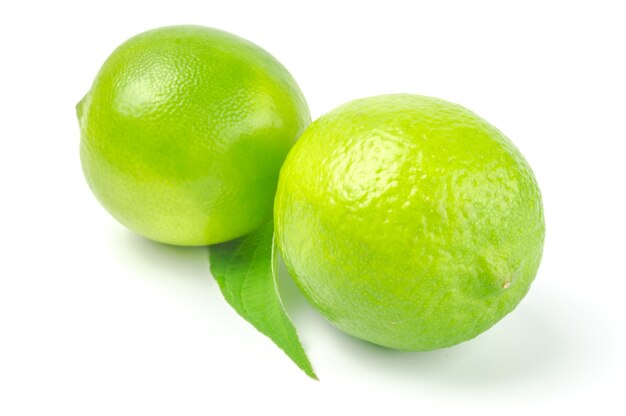 Two lime with leaf isolated on white cutout.