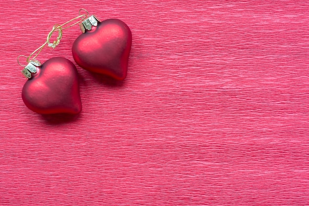 Two linked hearts on red paper background