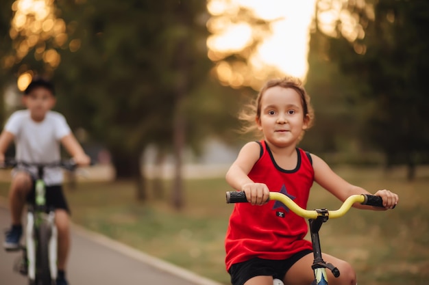 2 つの小さな男の子と女の子のサイクリストが自分の自転車に乗って楽しんで子供屋外スポーツ夏の活動
