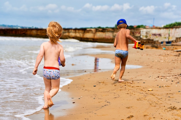 Two little boys are playing on the seashore