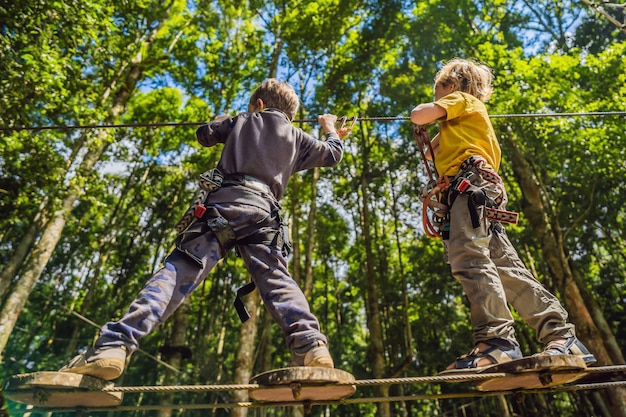 Two little boys in a rope park Active physical recreation of the child in the fresh air in the park Training for children