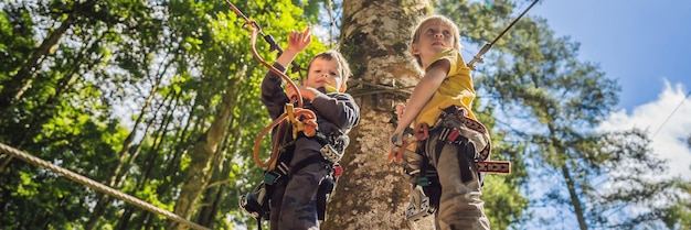 Photo two little boys in a rope park active physical recreation of the child in the fresh air in the park