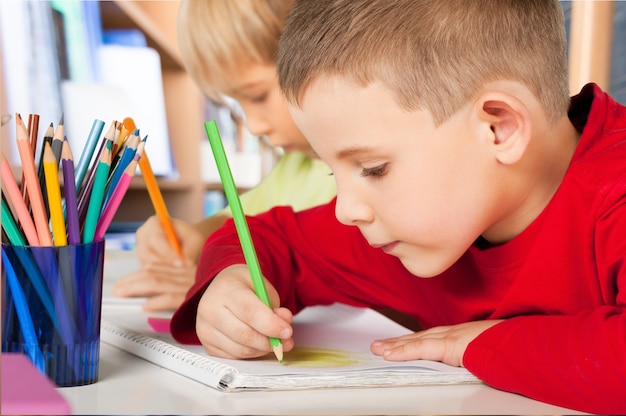 Two little boys studying subject on background