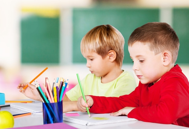 Two little boys studying subject on background