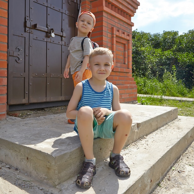 Two little brothers sitting in the summer park