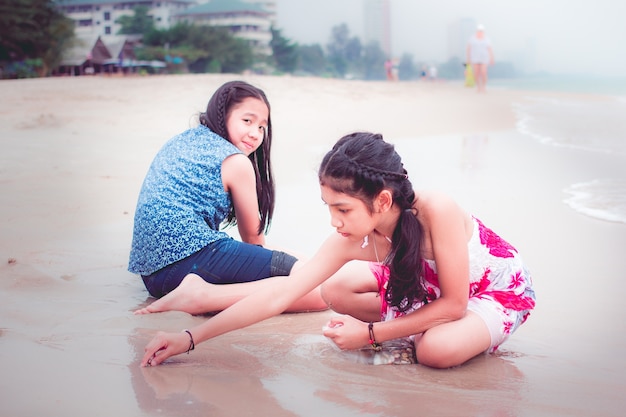 Two little girls are on the beach.