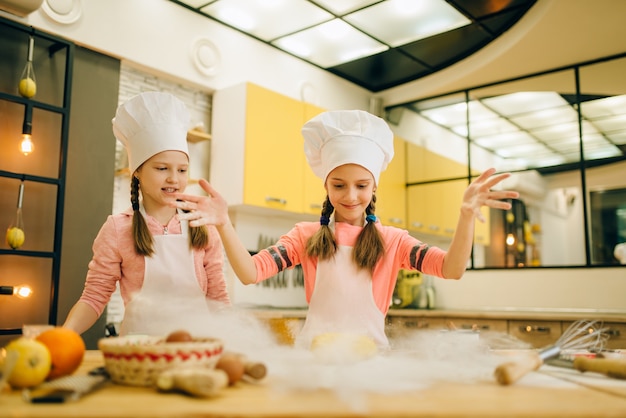 Photo two little girls chefs prepared dough