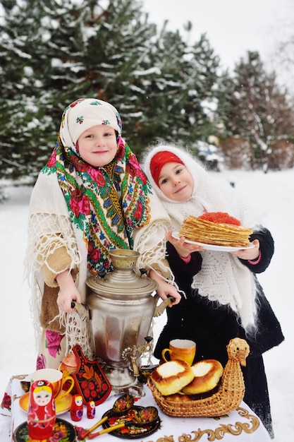 Two little girls in fur coats and shawls in Russian style