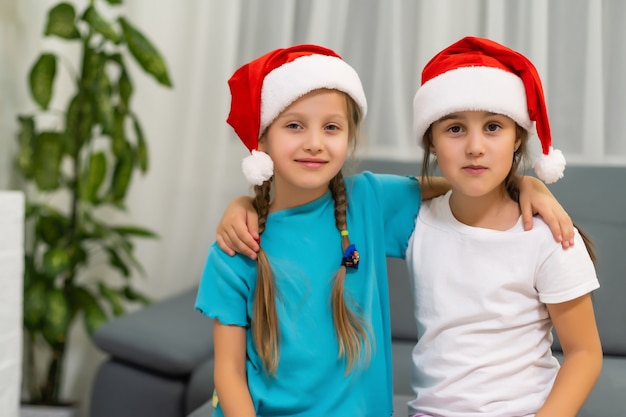 Two little girls in hats of Santa Claus l