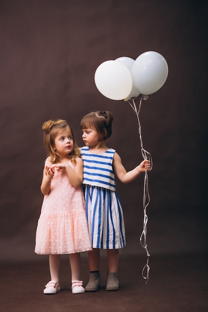 Two little girls models studio with balloons