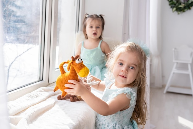 Two little girls playing with a toy horse