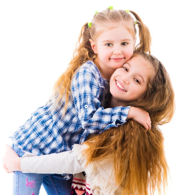 Two little girls sisters in casual clothes hugging