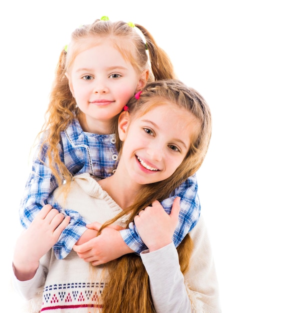 Two little girls sisters in casual clothes hugging