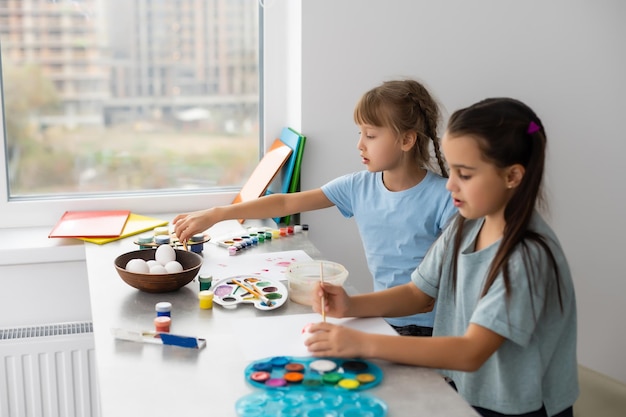 絵の具でテーブルにいる2人の少女