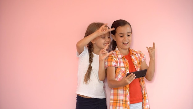 two little girls taking photo with a smartphone