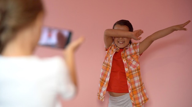 Photo two little girls taking photo with a smartphone