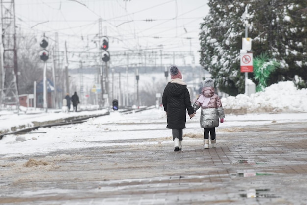 Two little girls walk along the platform of the railway station