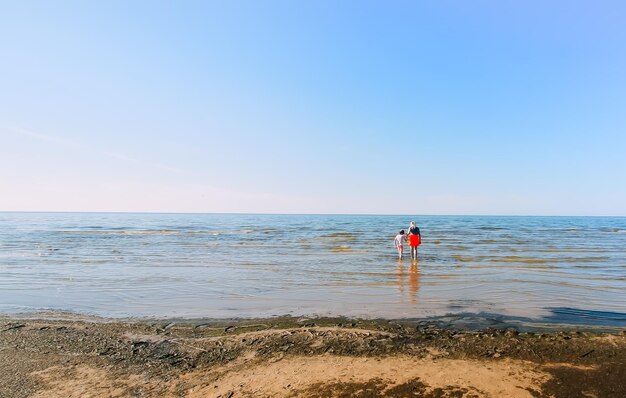 Two little girls walks on the beach