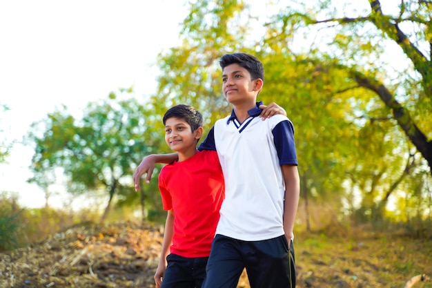 Two little indian brother walking on road