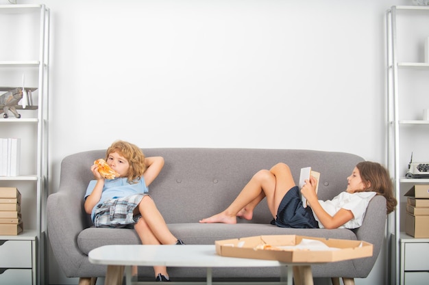 Two little kids eating pizza at home hungry children eating pizza pepperoni pizza for kids children