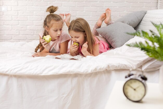 Photo two little kids girls play in the bedroom