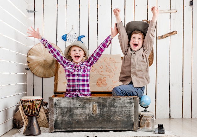 Due piccoli bambini che ridono con le mani in alto