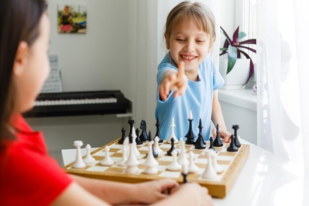 Two little sister playing chess at home