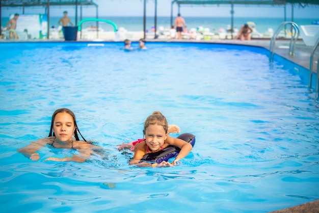 Two little sisters girls are swimming