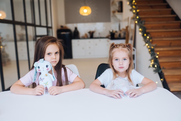 Two little sisters playing together at the table