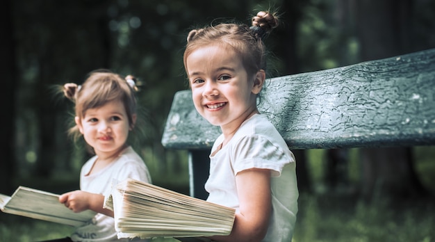 Two little sisters reading a book