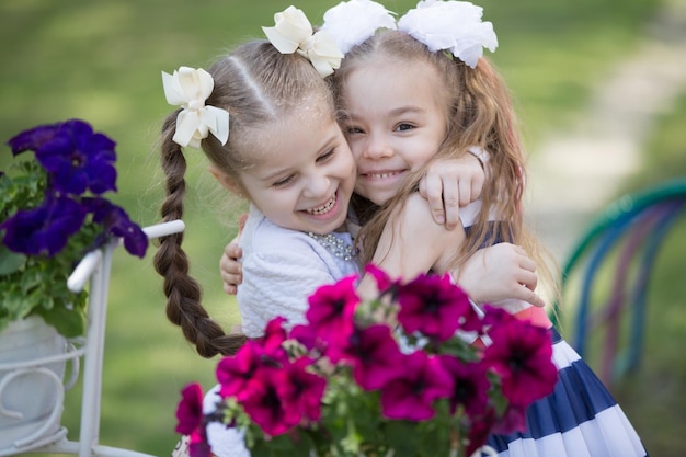 Two little sixyearold girlfriends embrace against a background of bright colors