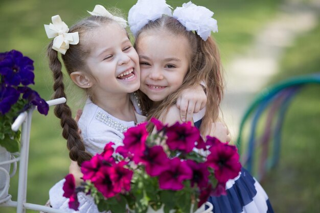 Two little sixyearold girlfriends embrace against a background of bright colors