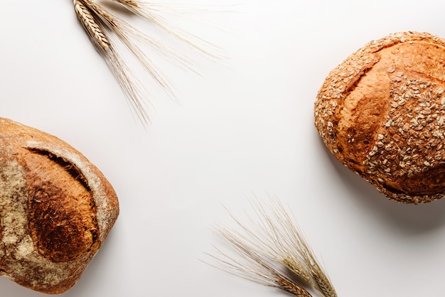 Two loaves of tasty rustic bread and ears of wheat