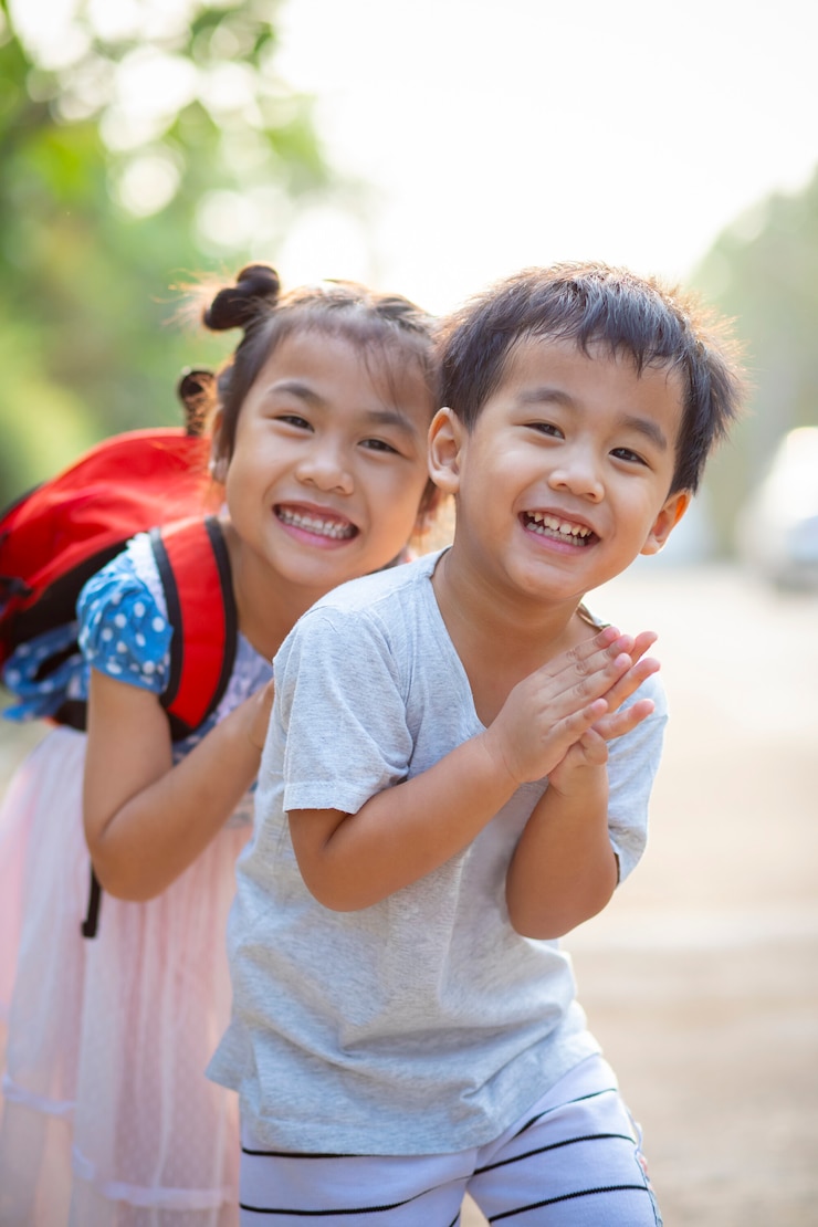 Photo 2つの素敵なアジアの子供男の子と女の子の笑顔をからかって