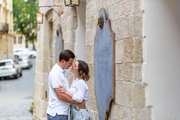 Due amanti si abbracciano per le strade della città vecchia durante un appuntamento. un momento prima del bacio.