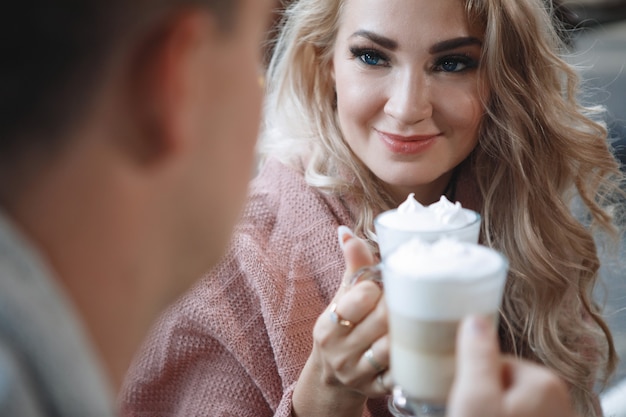 Due amanti, un uomo e una donna a un tavolo in un caffè. abbraccia, carezza, bevi latte. felice coppia tradizionale, felicità familiare.