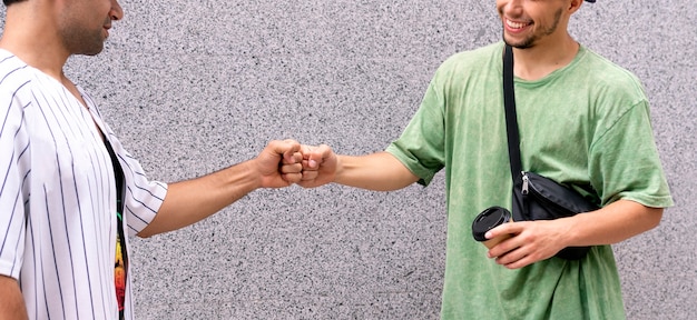 A two male friends cooperate and beat fists each ofther, teamwork and friendship concept