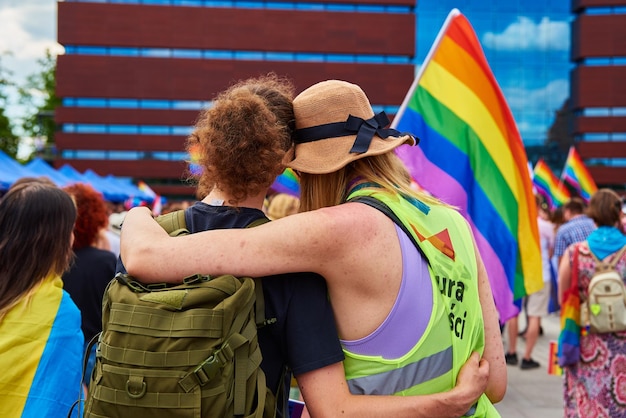 Two male friends with rainbow flags on pride demonstration