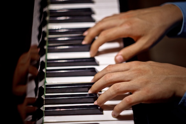 Two male hands on the piano.