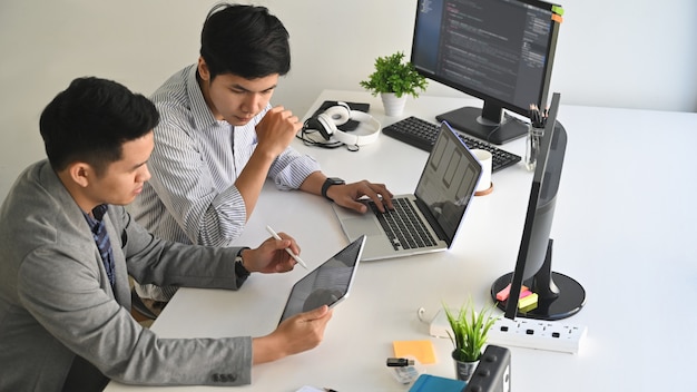 A two male programer working with laptop and coding on computer.